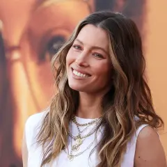 Jessica Biel sonríe con su pelo liso y mechas balayage, luciendo un collar de varias cadenas.