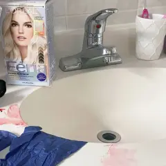 Kit para quitar tinte de cabello en el lavabo, con guantes, brocha y manchas rojas.