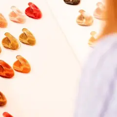 Una persona mira muestras de cabello para decidir qué color de pelo me favorece. Hay tonos rubios, castaños, rojizos y anaranjados.