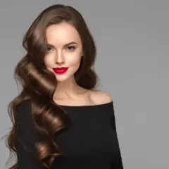 Mujer con peinados ondas media melena, labios rojos y vestido negro.