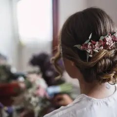 Moño bajo con flores para pelo corto en una boda. Un detalle romántico para el gran día.