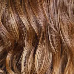 Cabello castaño con mechas rubias naturales que le dan un brillo y dimensión espectaculares.