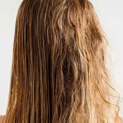 Cabello mojado y liso a un lado, y pelo roto y encrespado al otro, mostrando el contraste.