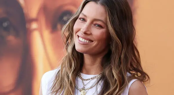 Jessica Biel sonríe con su pelo liso y mechas balayage, luciendo un collar de varias cadenas.