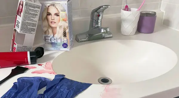 Kit para quitar tinte de cabello en el lavabo, con guantes, brocha y manchas rojas.