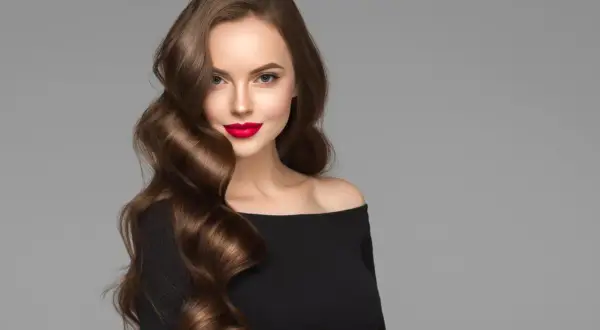 Mujer con peinados ondas media melena, labios rojos y vestido negro.