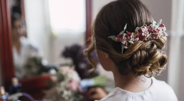 Moño bajo con flores para pelo corto en una boda. Un detalle romántico para el gran día.
