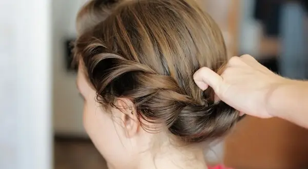 Manos expertas crean peinados trenzas boda, un recogido elegante y romántico para un día especial.