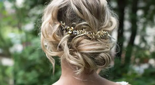 Recogido con trenzas boda, adornado con una delicada diadema dorada con detalles de pedrería.