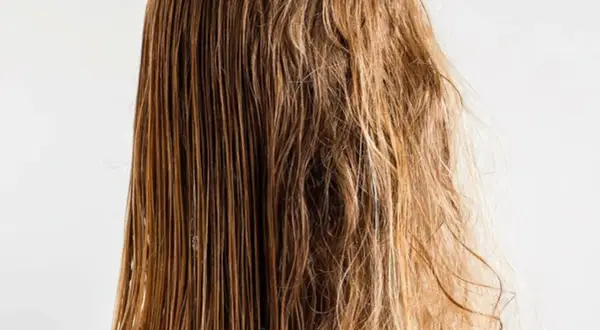 Cabello mojado y liso a un lado, y pelo roto y encrespado al otro, mostrando el contraste.