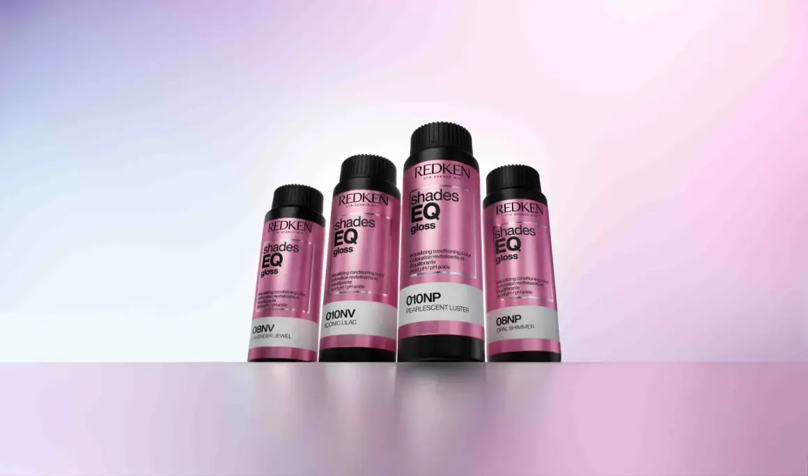 Cuatro botellas de baño de brillo para el pelo Redken Shades EQ Gloss en tonos perlados y lilas, listas para dar un acabado radiante.