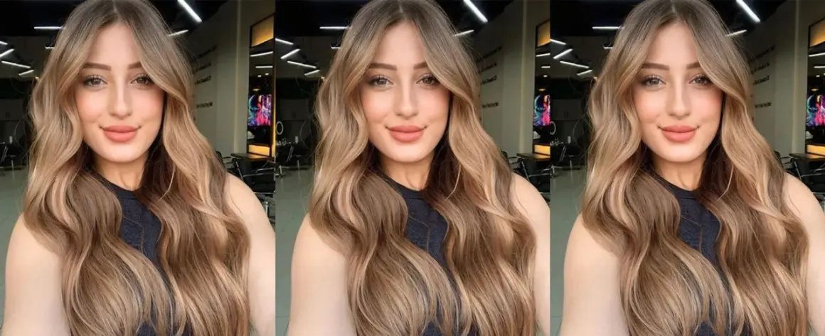 Mujer con cabello largo y ondulado con mechas balayage en tonos miel y caramelo.