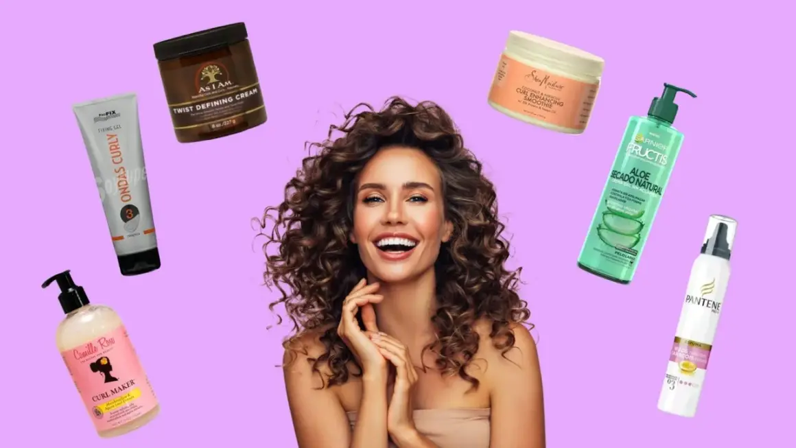 Mujer sonriente con rizos perfectos, rodeada de productos para el cabello: cremas, geles y espumas para definirlos.
