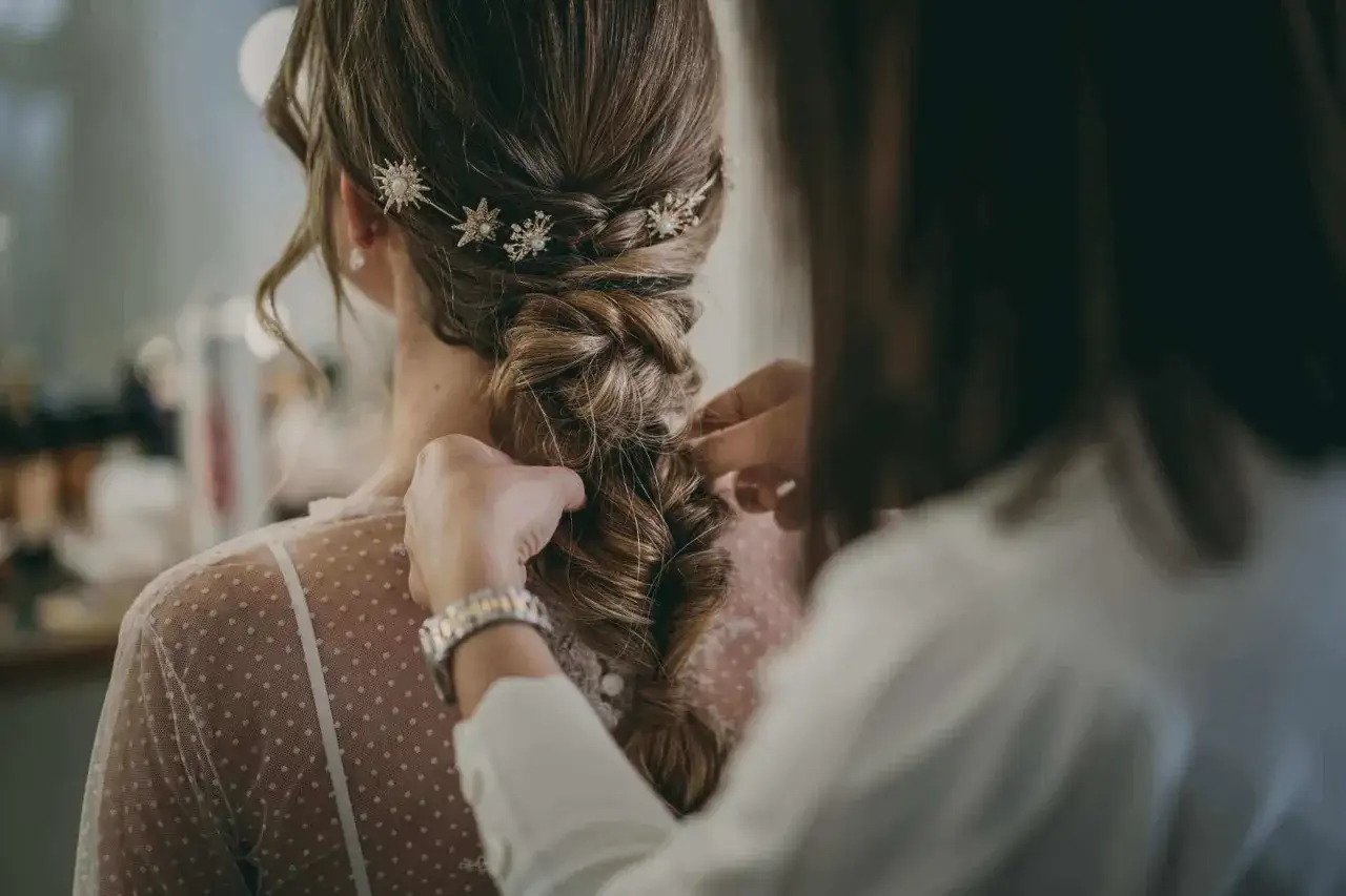 Peinado de novia con trenza y adornos de estrellas.