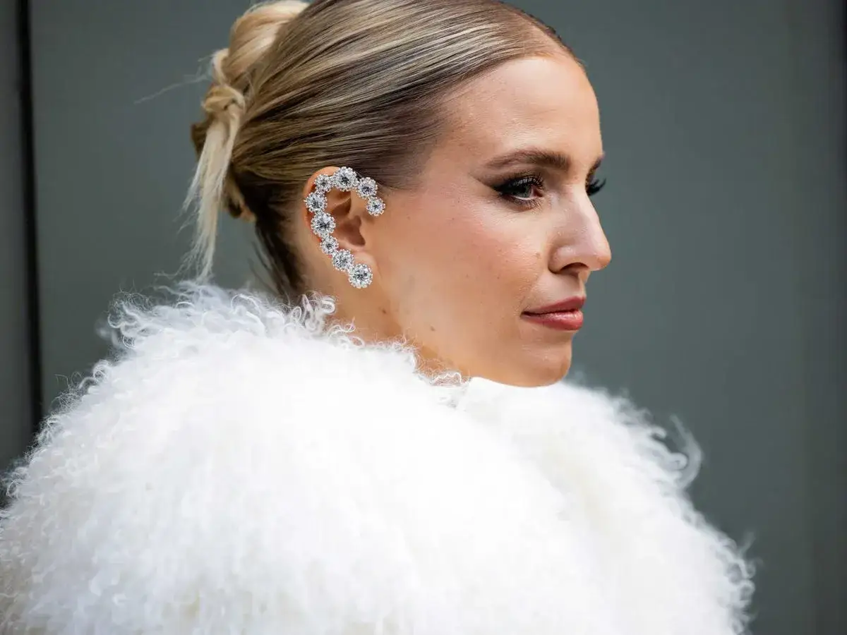 Elegante peinado moño boda con un llamativo pendiente de brillantes en forma de corazón.