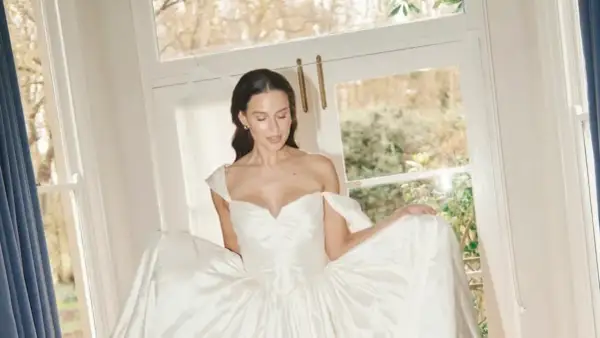 Novia radiante con un vestido de ensueño, ideal para los pelos para bodas. Luz natural y ventana al jardín.