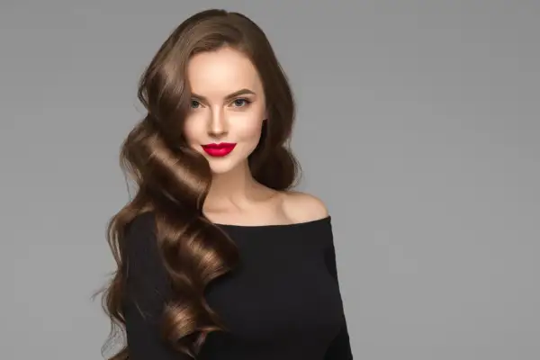 Mujer con peinados ondas media melena, labios rojos y vestido negro.